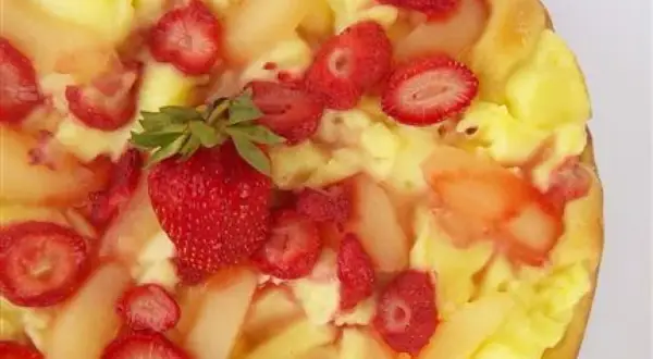 Słodka pizza z kremem budyniowym, truskawkami i kawałkami gruszek. Idealna na deser.