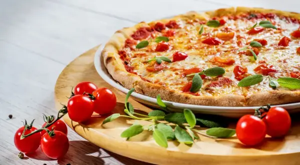 Pyszna pizza z pomidorkami i bazylią, choć ser może podnosić cholesterol, smakuje wybornie.