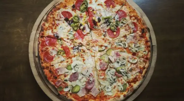Apetyczna pizza 42 cm z salami, papryczkami jalapeño, kukurydzą, pieczarkami i ogórkiem. Zastanawiasz się, ile waży pizza 42 cm?