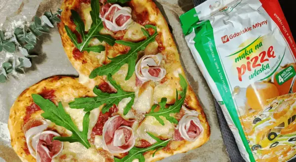 Serce z pizzy z szynką i rukolą obok mąki "Maka na pizzę włoską" - idealna do domowego wypieku.