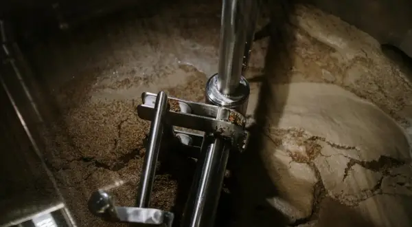 Wnętrze kadzi filtracyjnej z widocznym osadem i elementami mechanicznymi.