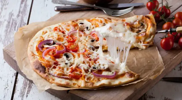 Pyszna pizza 32 cm z ciągnącym serem, pomidorkami i cebulą. Zastanawiasz się, ile gram ciasta na pizzę 32 cm? To idealna porcja!