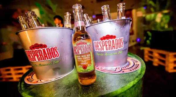 Butelki Desperados w wiaderkach, jedna z nich pokazuje zawartość alkoholu 5,9% vol.
