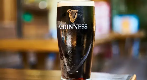 Szklanka Guinnessa, ciemnego piwa z pianką, którego barwa i smak wynikają ze słodu jęczmiennego.