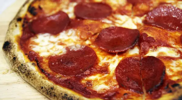 Pyszna pizza pepperoni z ciągnącym serem. Czy można przygotować pizzę wcześniej? Tak, można ją upiec i odgrzać.