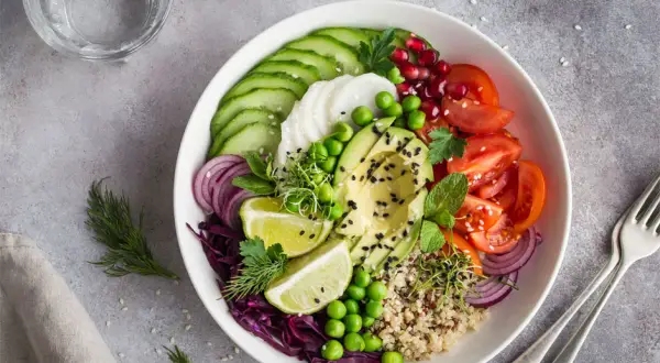 Kolorowy bowl z awokado, pomidorami, ogórkiem i czerwoną kapustą. Idealne przepisy na zdrowy posiłek.