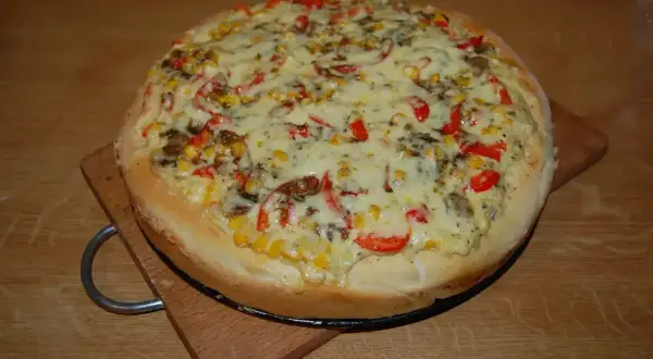Domowa pizza z kukurydzą, papryką i pieczarkami, idealnie doprawiona. Zastanawiasz się, jakie przyprawy do pizzy wybrać?