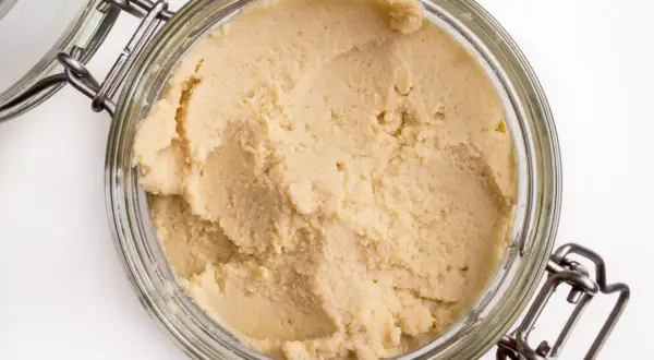 Gładka, kremowa masa w słoiku. To właśnie co to jest hummus, pyszna pasta z ciecierzycy.