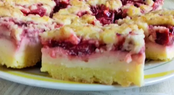 Kruche ciasto z budyniem i owocami wiśni, posypane kruszonką. Pyszny deser na talerzu.