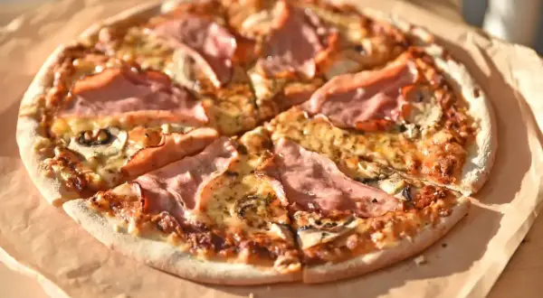 Pizza z szynką i pieczarkami, idealna na szybki obiad. Dowiedz się, jak przygotować pieczarki na pizzę, by były pyszne!