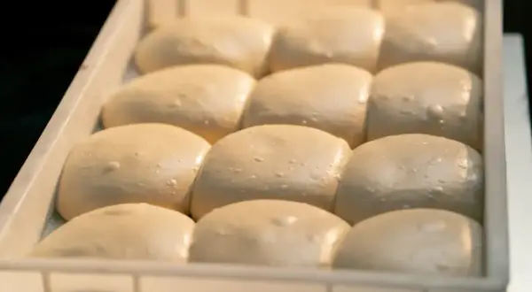 Gotowe do pieczenia ciasto na pizzę w lodówce. Porcje ciasta czekają na swoją kolej, by stać się pyszną pizzą.