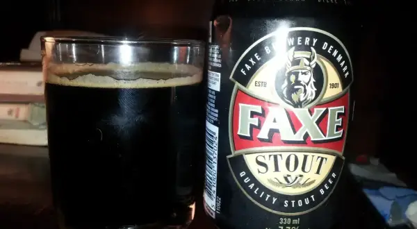 Szklanka ciemnego piwa Faxe Stout obok puszki. To piwo 2 procent, idealne na wieczór.