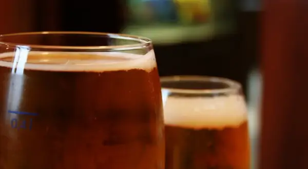 Dwa szklanki piwa, z pianką i bąbelkami. Na pierwszej widać oznaczenie 0,4l. Idealny piwny zacier na wieczór.