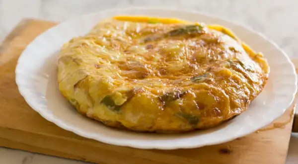 Złocista tortilla ziemniaczana z papryką na talerzu. Idealne śniadanie bez chleba, sycące i pyszne.