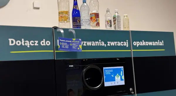 Na automacie do zwrotu opakowań stoją puste butelki. Widać, które butelki są zwrotne po piwie i innych napojach.