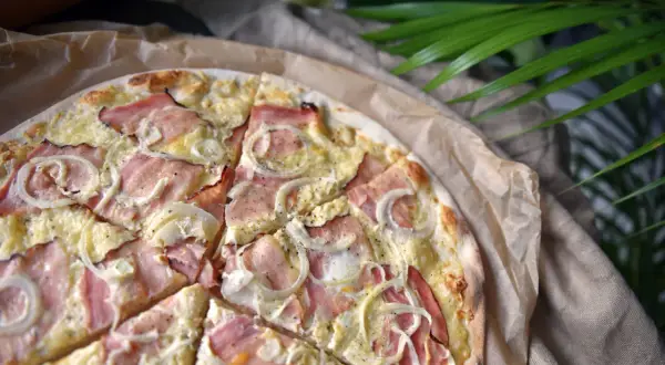 Pyszna pizza z szynką i cebulą, idealna na szybki obiad. Jaka szynka do pizzy? Najlepiej delikatna, która nie zdominuje smaku.