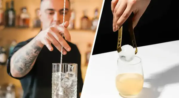 Barman miesza drink z lodem. Ktoś dodaje kulę lodu do drinka. Idealne piwo z lodem na upalne dni.