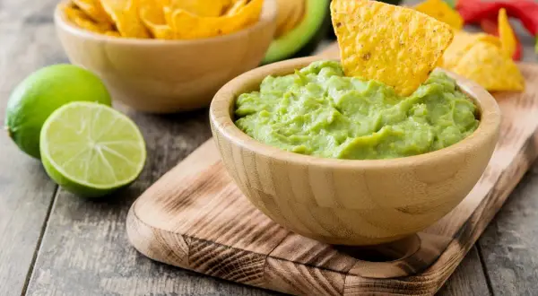 Pyszne guacamole z awokado, limonką i chrupiącymi nachosami. Idealne jako przekąska, z czym jeść guacamole? Z nachosami!