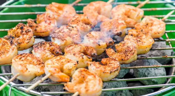 Krewetki marynata na grillu, dymiące i rumiane, gotowe do podania.