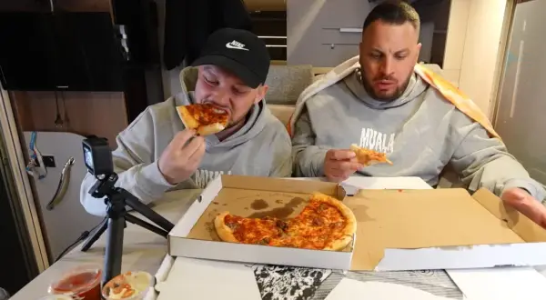 Dwóch mężczyzn je pizzę, jeden z nich próbuje najostrzejszej pizzy w Polsce.