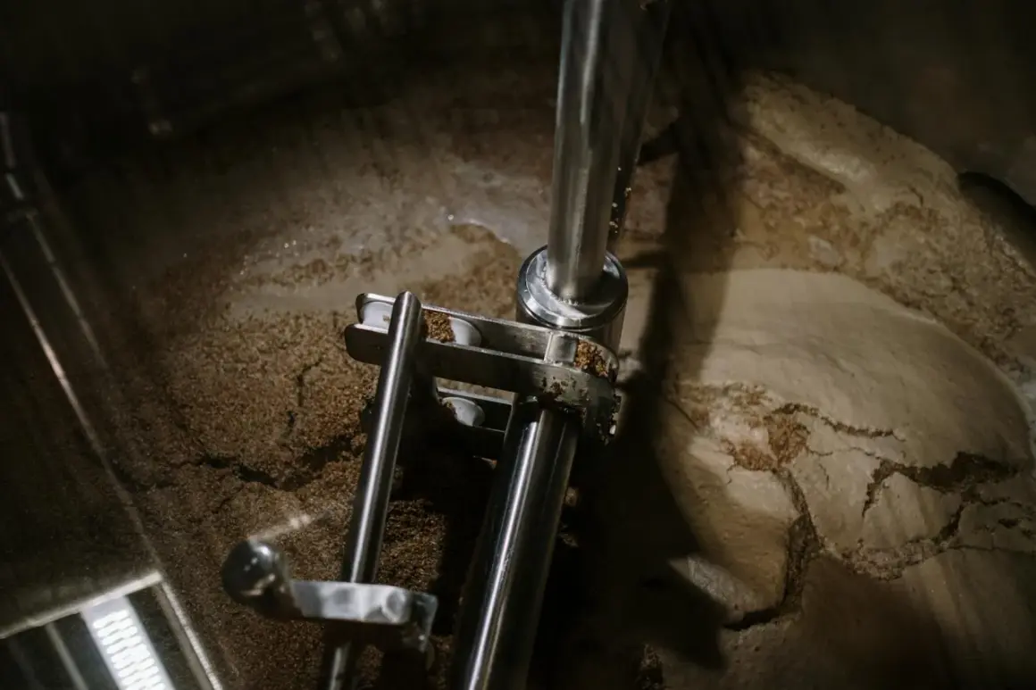 Wnętrze kadzi filtracyjnej z widocznym osadem i elementami mechanicznymi.