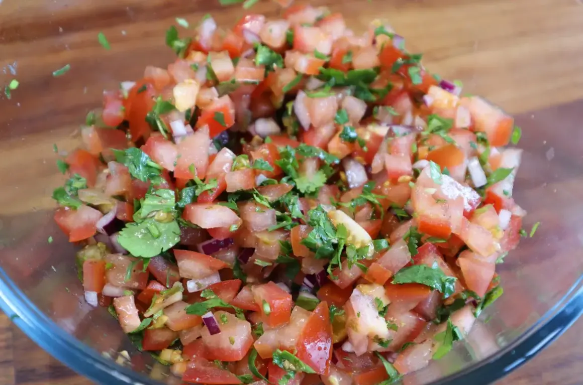 Świeża salsa pico de gallo z pomidorów, cebuli i kolendry w szklanej misce. Idealna do nachos!