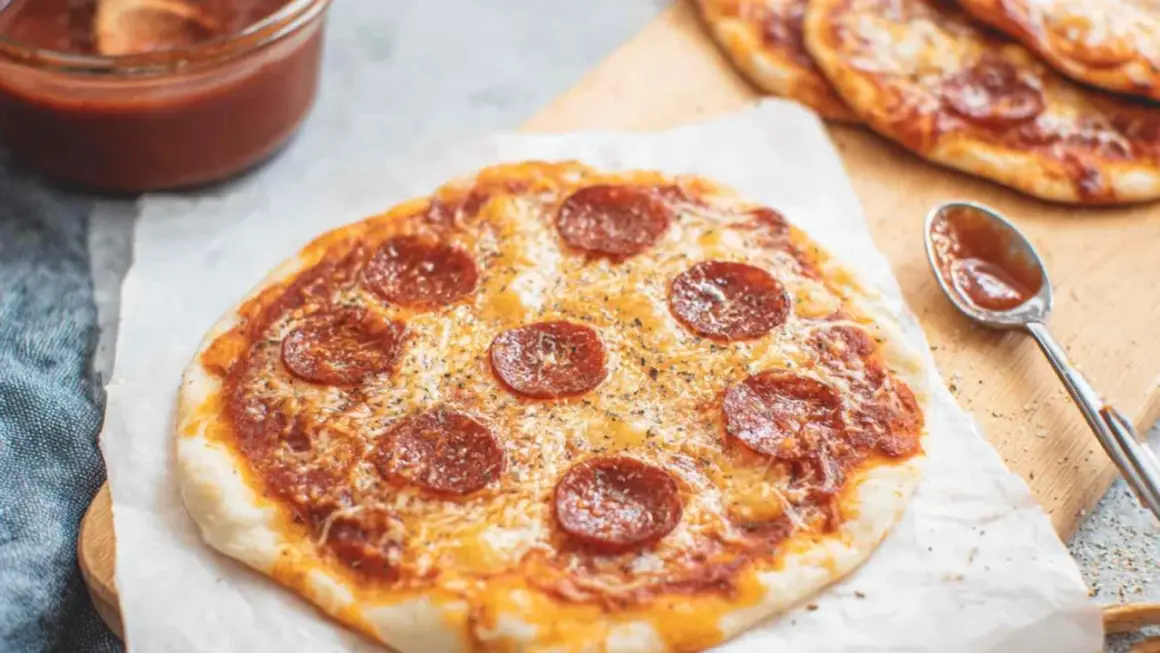 Pyszna pizza z tortilli z pepperoni i serem, obok sos i łyżeczka.
