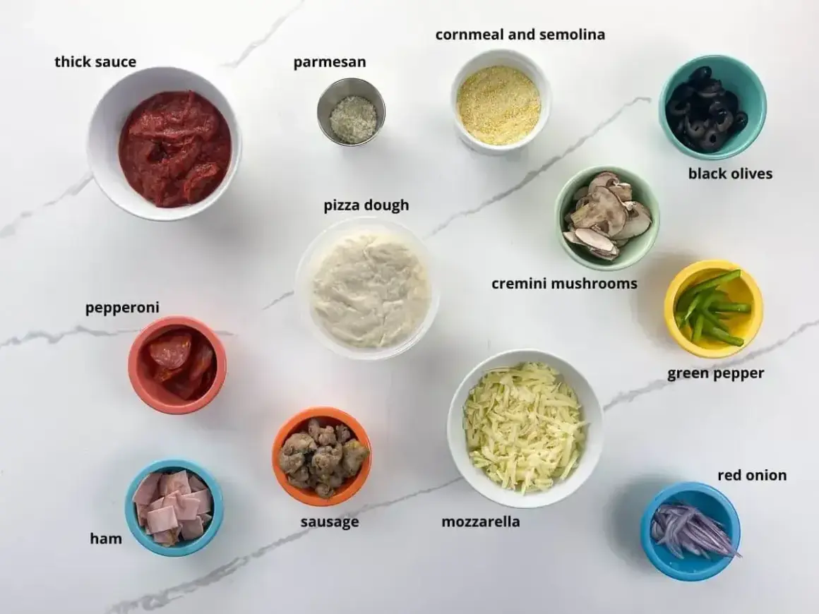 Składniki do pizzy: sos, ser, ciasto, pepperoni, szynka, kiełbasa, pieczarki, oliwki, papryka, cebula, parmezan, mąka kukurydziana.