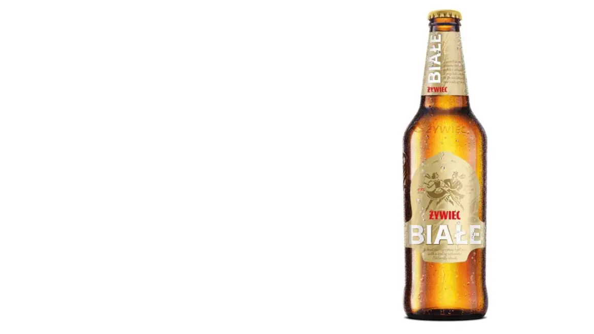 Butelka piwa Żywiec Białe z kroplami rosy na szkle.