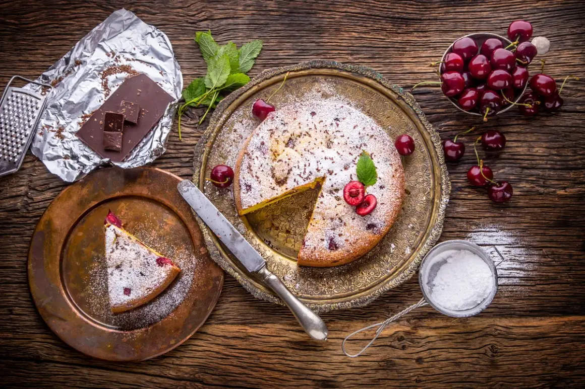 Pyszny kawałek ciasta drożdżowego z wiśniami, posypany cukrem pudrem. Idealny deser, choć warto pamiętać o jego kcal.