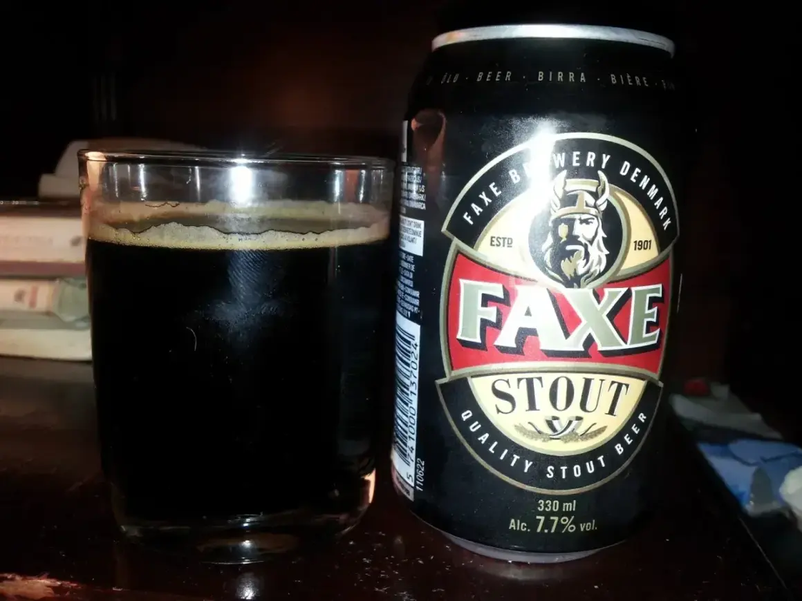 Szklanka ciemnego piwa Faxe Stout obok puszki. To piwo 2 procent, idealne na wieczór.