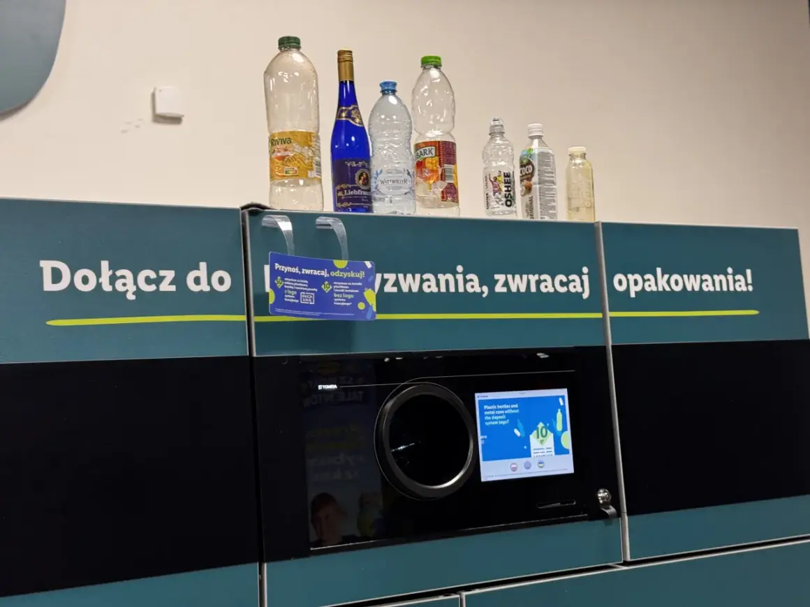 Na automacie do zwrotu opakowań stoją puste butelki. Widać, które butelki są zwrotne po piwie i innych napojach.