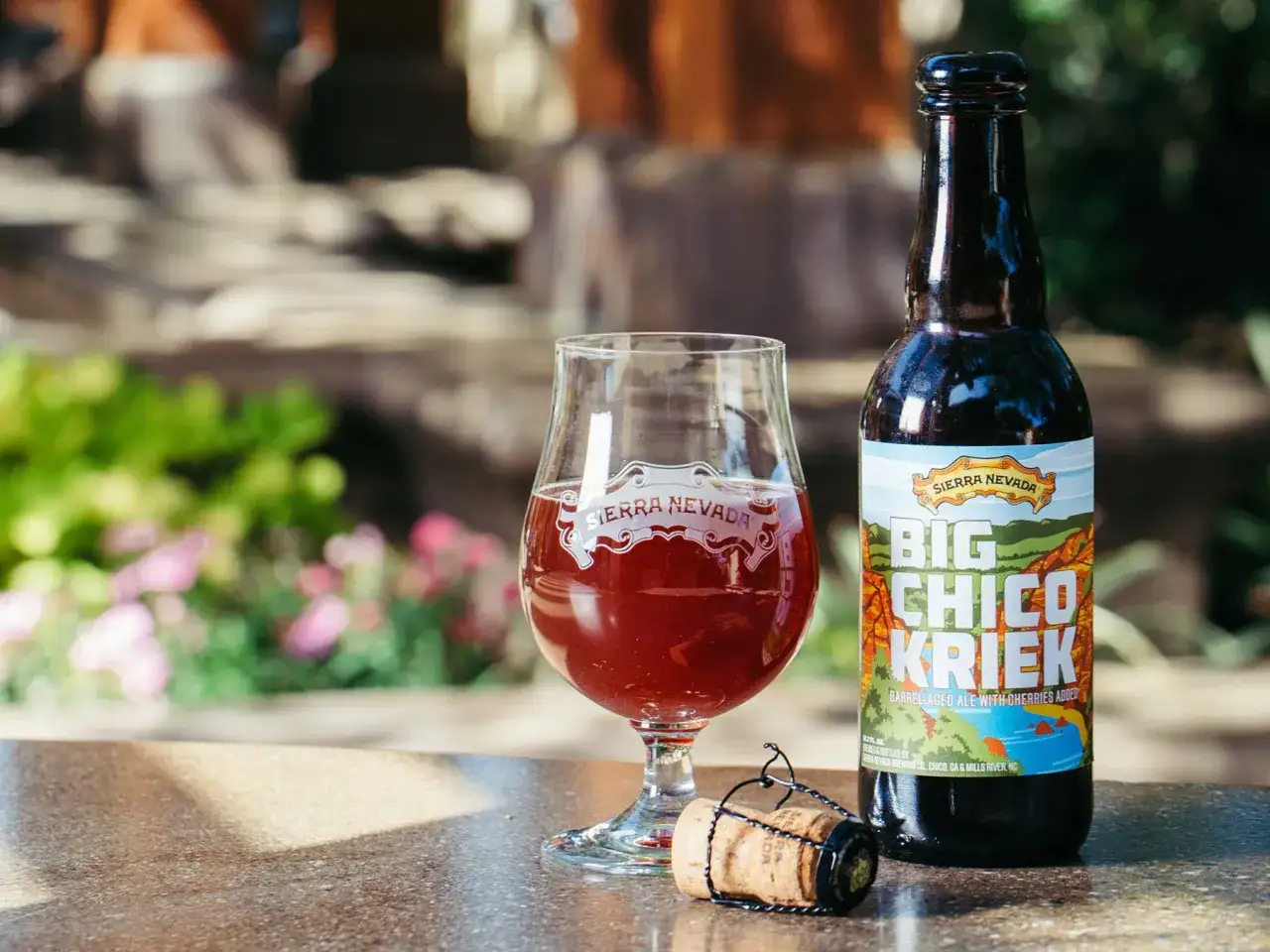 Szklanka z czerwonym piwem sour obok butelki Sierra Nevada Big Chico Kriek.