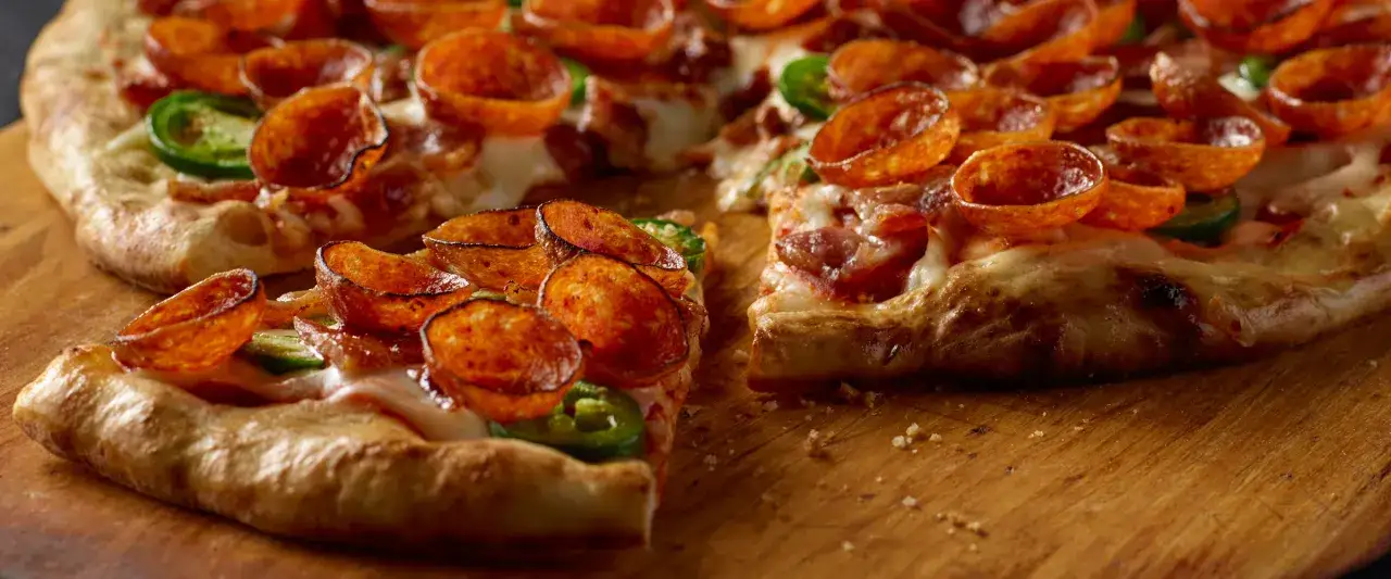 Pyszna pizza ostro z pepperoni i papryczkami jalapeño, idealna na wieczór z przyjaciółmi.