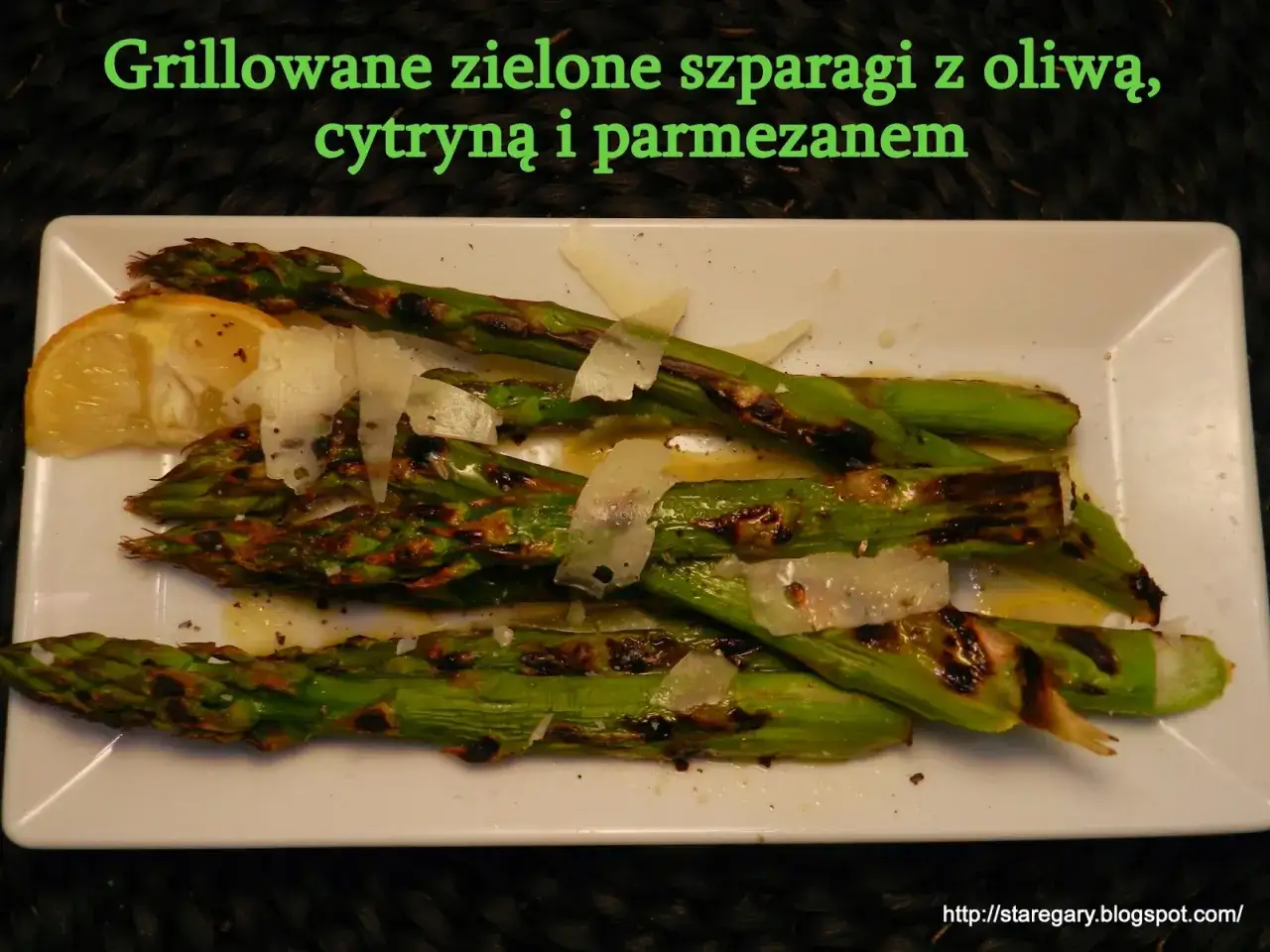Grillowane szparagi z cytryną i parmezanem, lekko przypieczone, podane na białym talerzu.