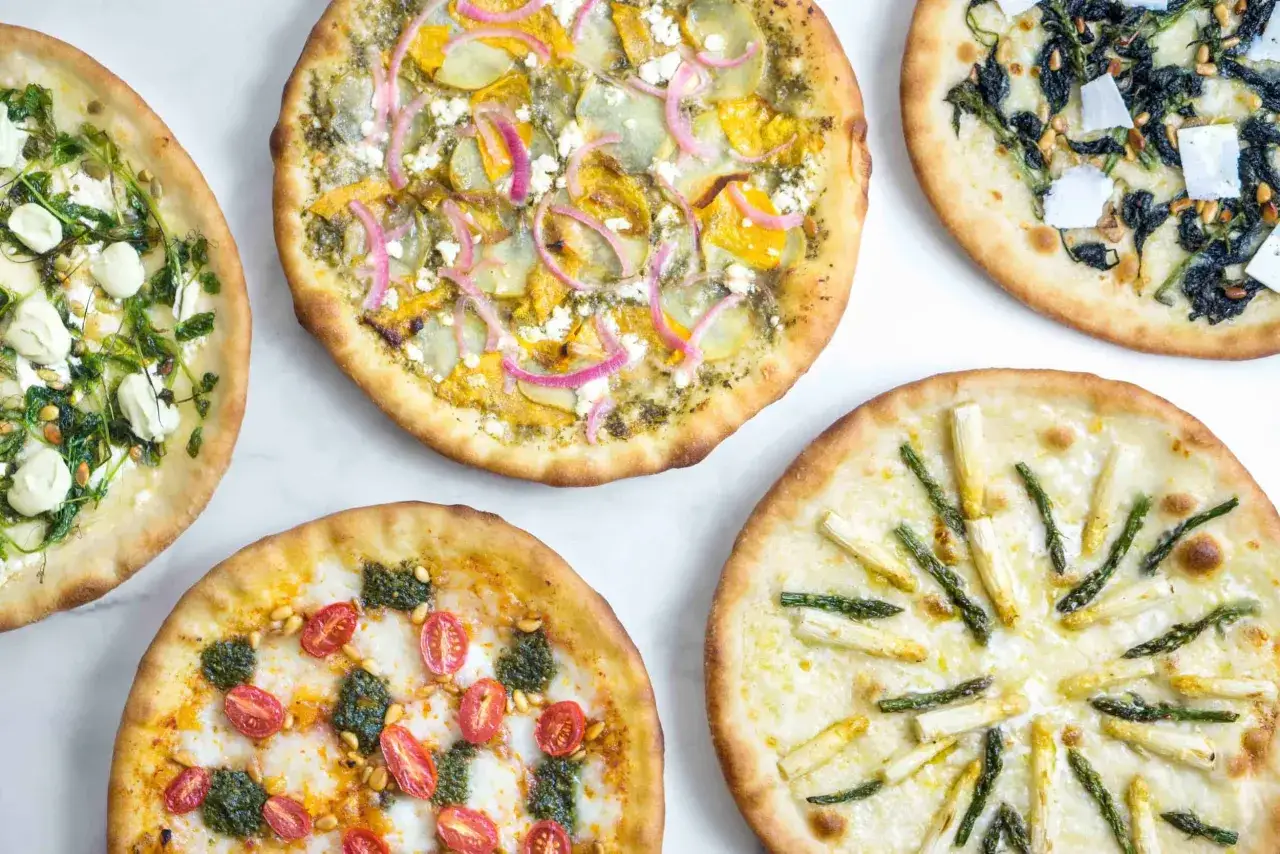 Pięć nietypowych pizz: z pomidorkami i pesto, szparagami, dynią i fetą, szpinakiem i orzeszkami pinii, oraz z zielonymi warzywami i serem.