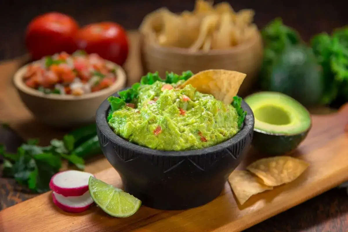 Pyszne guacamole Ani Gotuje, podane z nachos, awokado i limonką. Idealne na imprezę!