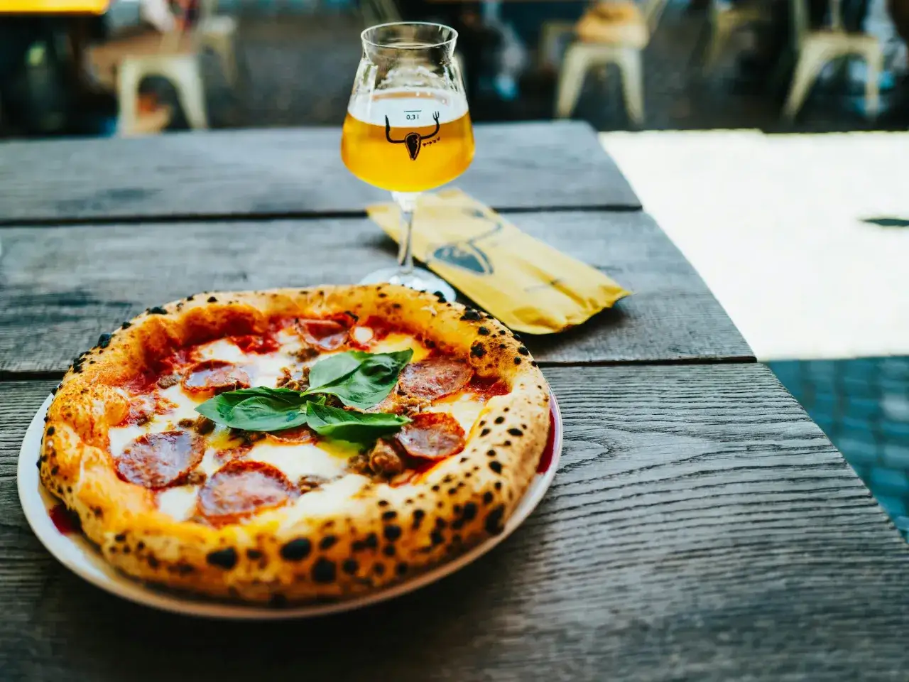 Idealne połączenie: pyszna pizza z piwem na drewnianym stole.