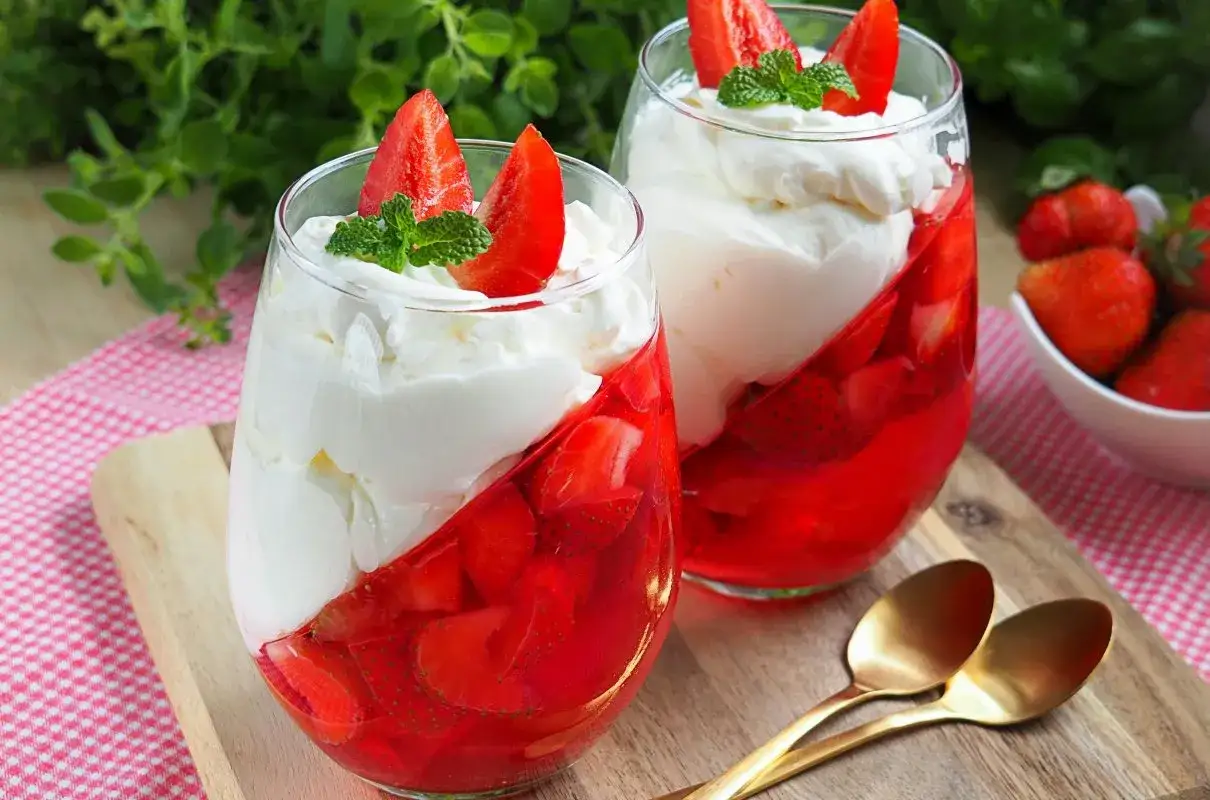 Pyszny deser z truskawkami i bitą śmietaną, gdzie lekki serek mascarpone tworzy idealną bazę.