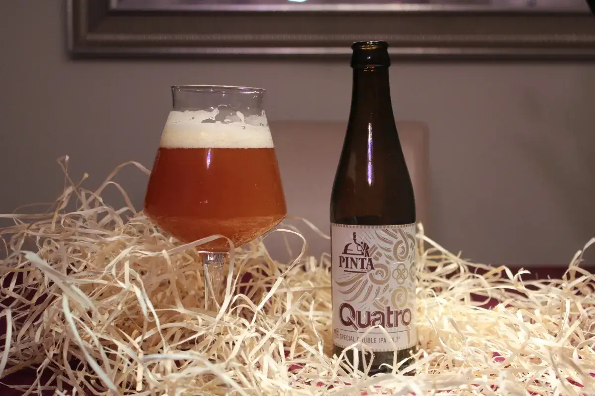 Szklanka z bursztynowym piwem IPA i butelka