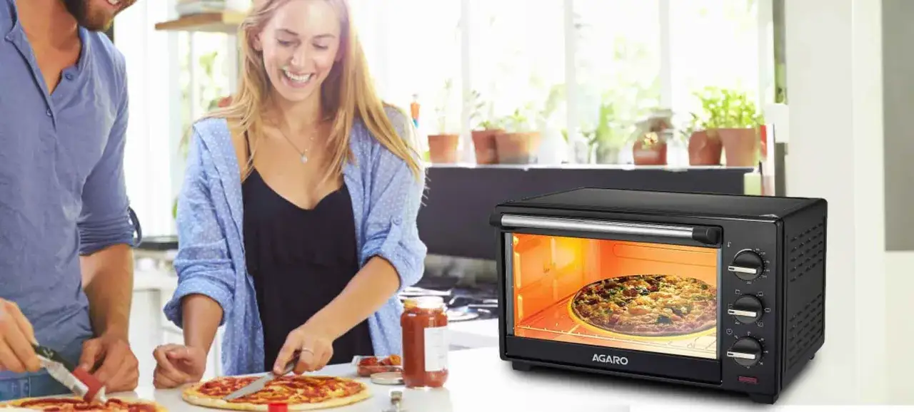 Para przygotować idealną pizzę na spodzie do pizzy, para smaruje sos na ciasto, podczas gdy w piekarniku AGARO piecze się gotowa pizza.
