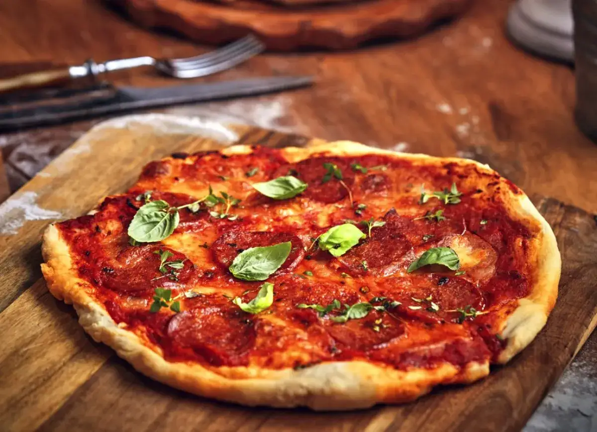 Pizza z salami, pomidorami i świeżą bazylią. Idealne dodatki dla miłośników klasyki.