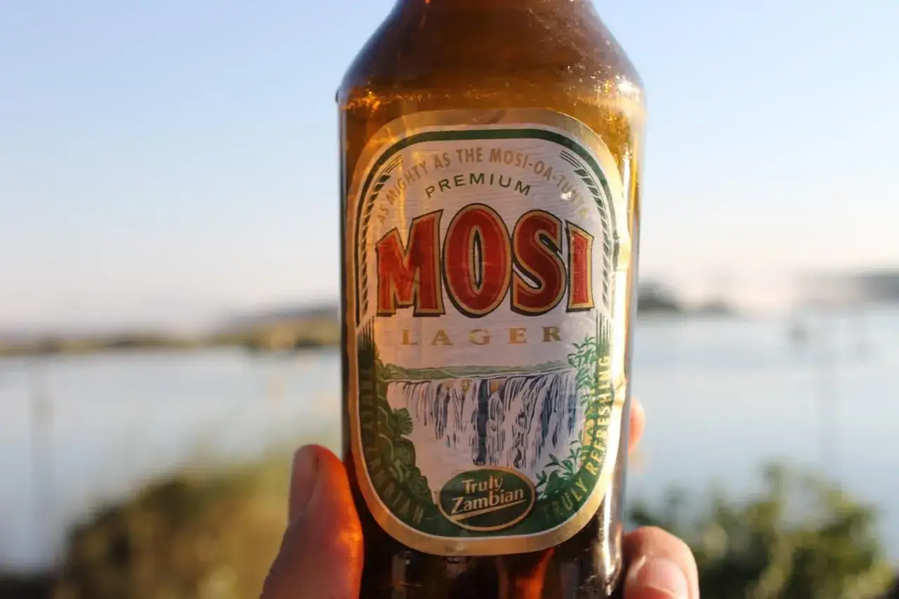 Butelka piwa Mosi Lager z etykietą przedstawiającą wodospad. Ciesz się orzeźwiającym piwo lager smak.