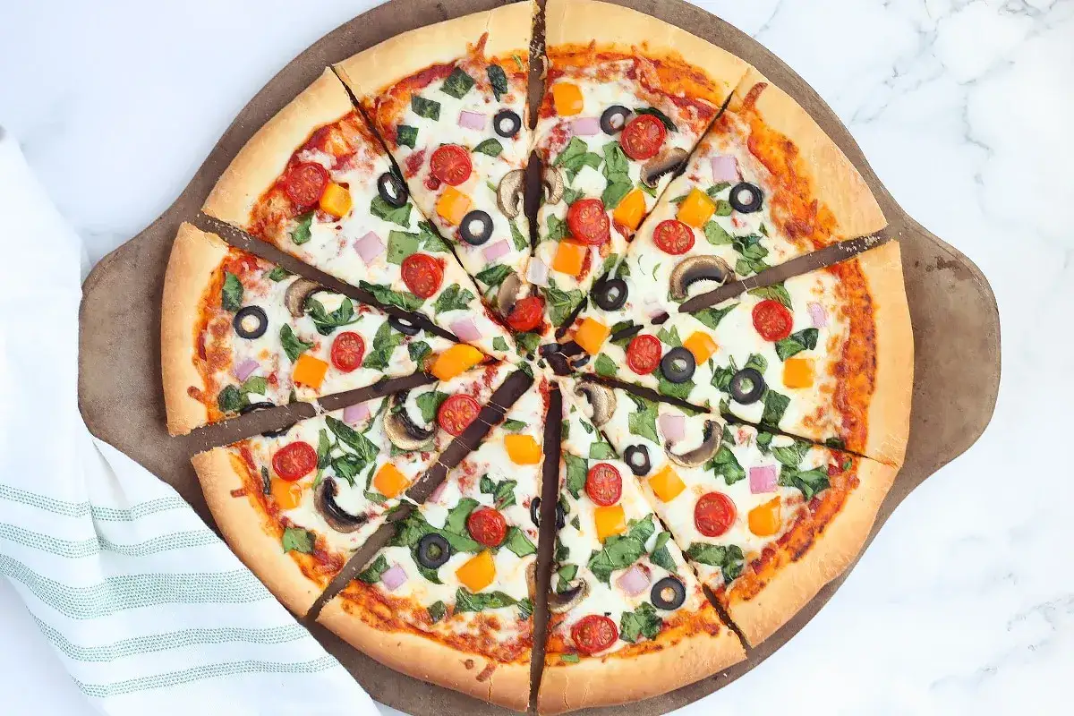 Pyszna pizza wege z pomidorkami, oliwkami, pieczarkami i papryką. Idealna na szybki obiad lub kolację.
