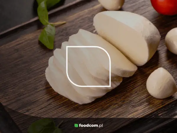 Różne rodzaje mozzarelli: kulki, plastry i blok na desce z bazylią i czosnkiem.