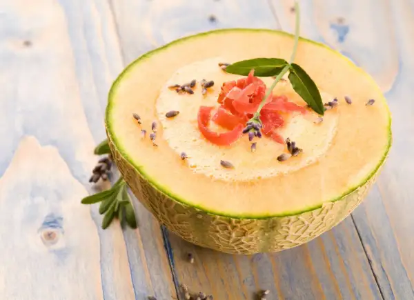 Jak jeść melona? Pokrojony na pół, z pianką, szynką parmeńską, lawendą i listkami. Pyszna inspiracja.