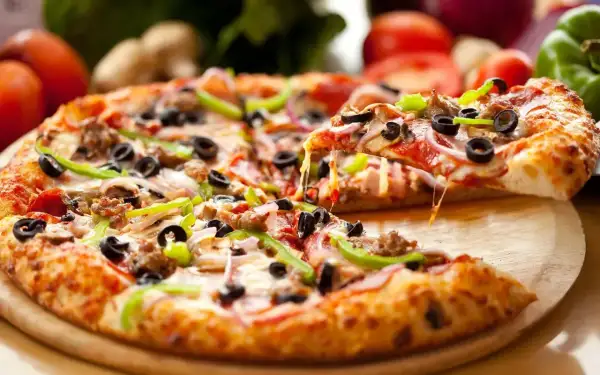 Pyszna pizza z serem, oliwkami i papryką, idealna na światowy dzień pizzy.