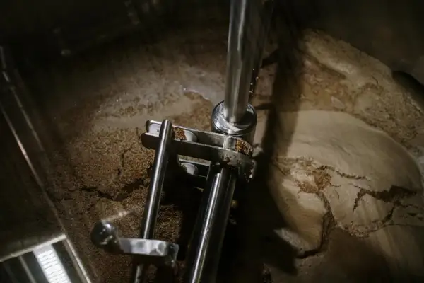 Wnętrze kadzi filtracyjnej z widocznym osadem i elementami mechanicznymi.