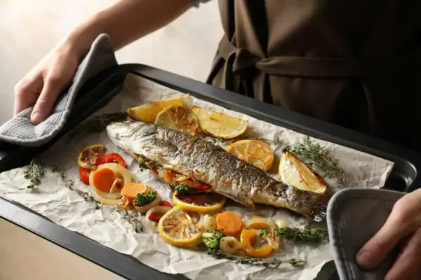 Pyszny filet z pstrąga z piekarnika, pieczony z cytryną, warzywami i ziołami.
