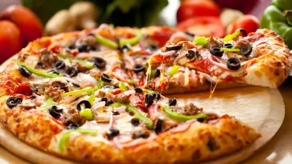 Pyszna pizza na spodzie do pizzy, z ciągnącym serem, oliwkami, papryką i salami. Idealna na spotkanie z przyjaciółmi.